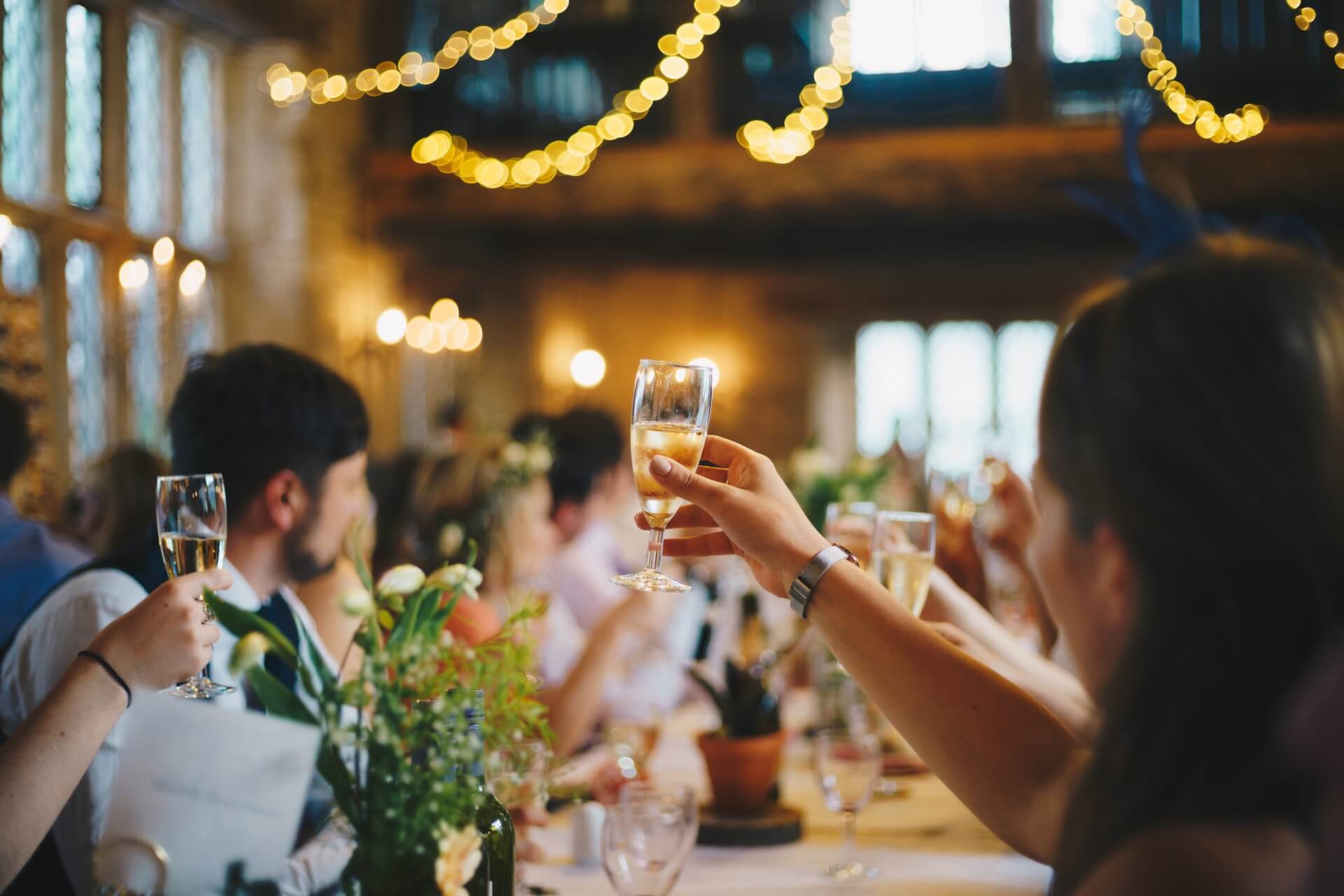 Group of people celebrating a special event and raising their glasses to toast